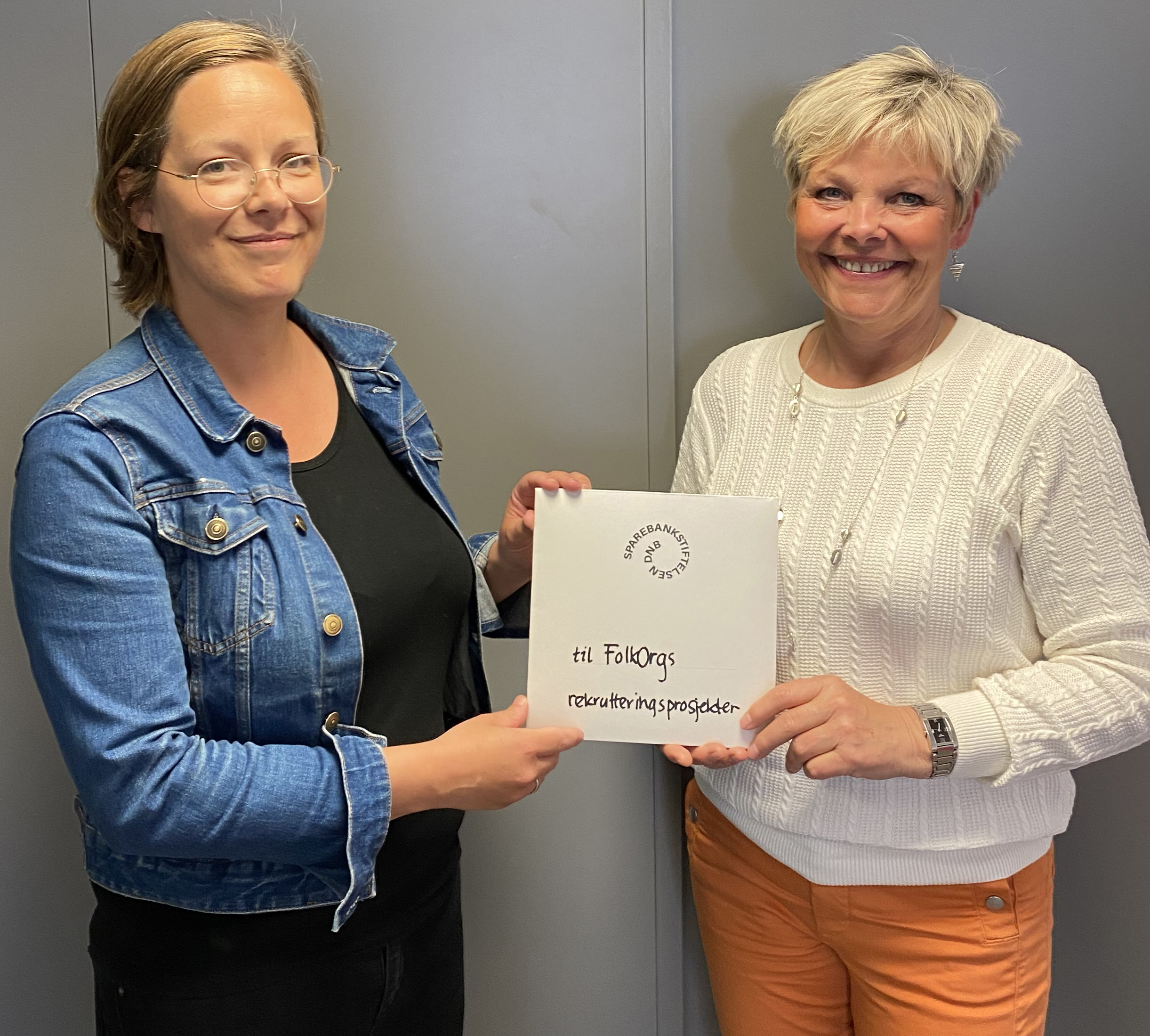 Eline Melgalvis overrekker synleg prov på pengegåva til styreleiar i FolkOrg, Hilde Reitan