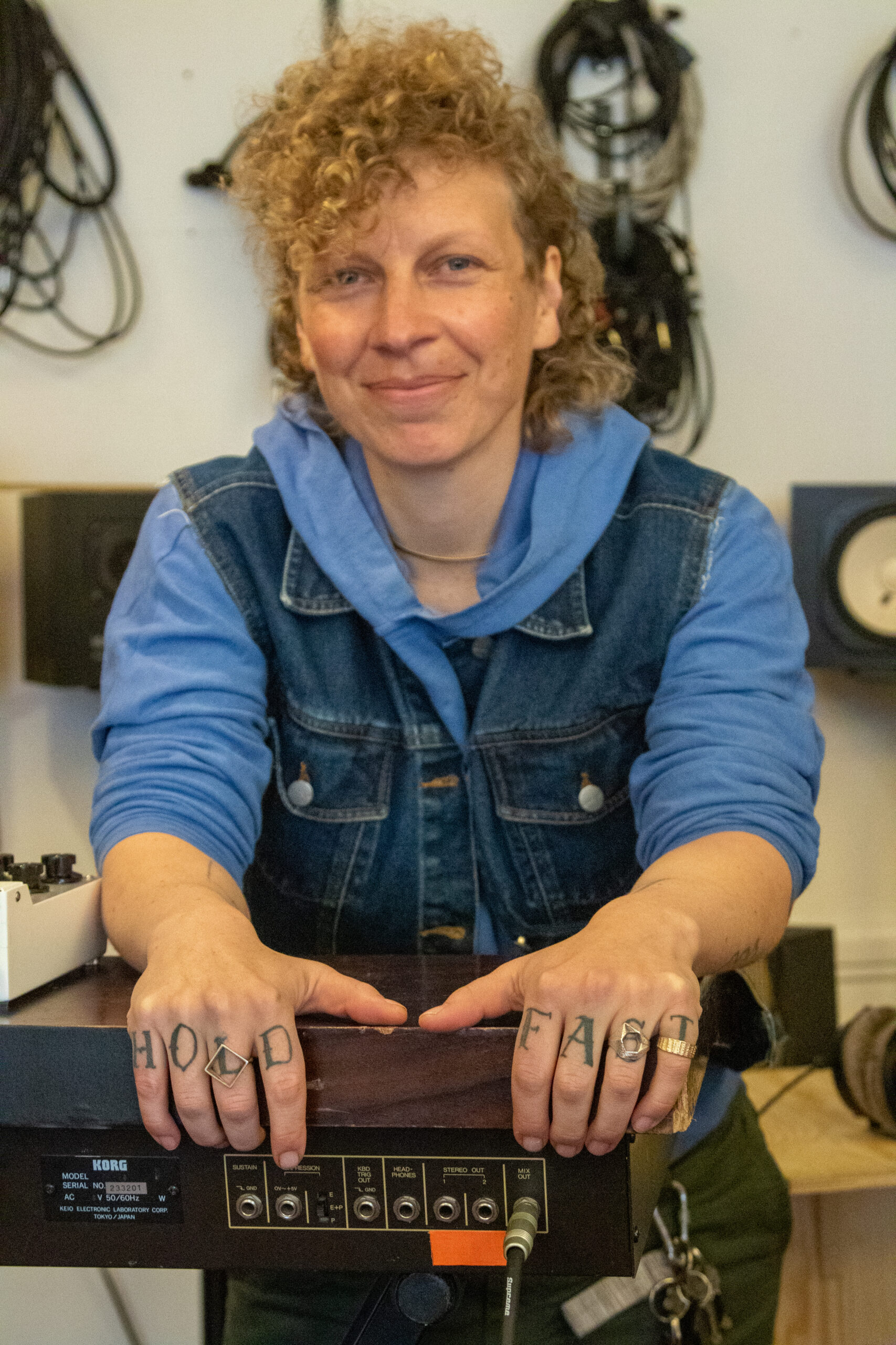 Blond kvinne, stående, tatoverte hender holder rundt en mikser