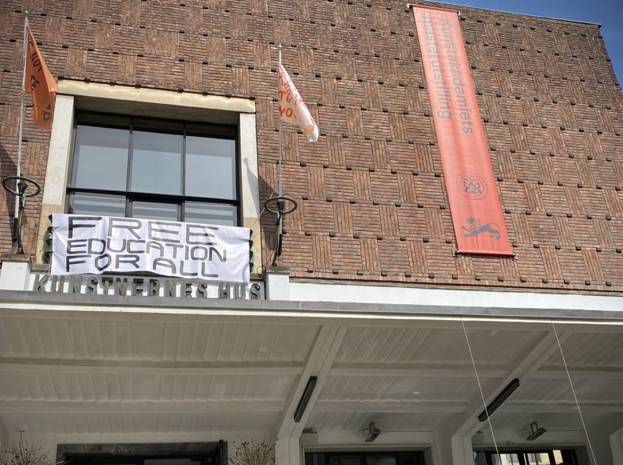 Avgangsstudentene ved Kunstakademiet i Oslo ber om «free education for all» på husfronten på Kunstnernes Hus. Utstillinga inkluderer en panelsamtale om de økte studieavgiftene fredag 12. mai.