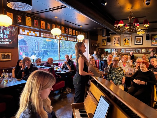 Interiør fra pub i Oslo, vi ser pianist Olga Jørgensen og sanger Frida Augusta Gudim